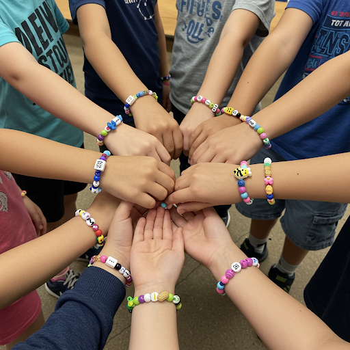 Hands of children wearing colorful bead bracelets, joined in a circle.